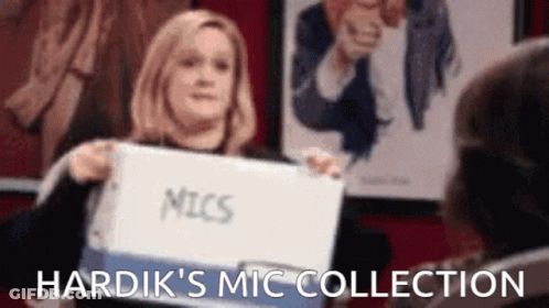 A Woman Is Holding A Binder With The Word Mic Written On It . GIF