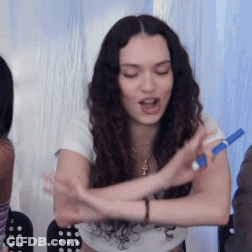 A Woman Is Holding A Blue Marker In Her Hand GIF