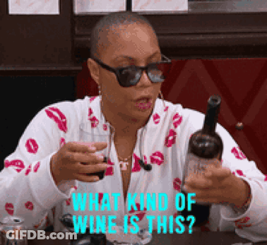 A Woman Is Holding A Bottle Of Wine And A Glass Of Wine And Asking What Kind Of Wine Is This ? GIF