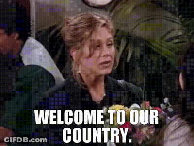 A Woman Is Holding A Bouquet Of Flowers And Says Welcome To Our Country GIF