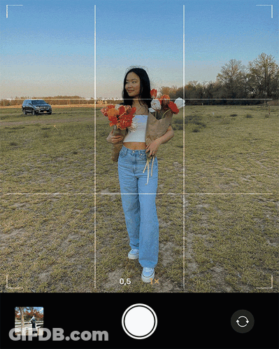 A Woman Is Holding A Bouquet Of Flowers In A Field With The Number 0.5 Visible GIF