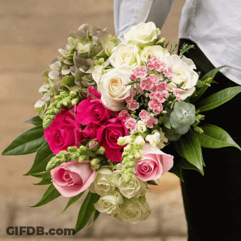 A Woman Is Holding A Bouquet Of Pink And White Roses GIF