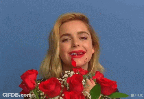 A Woman Is Holding A Bouquet Of Red Roses And Has Blood On Her Face . GIF
