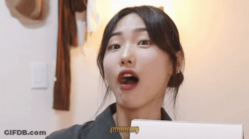 A Woman Is Holding A Box That Says Gummy On It GIF