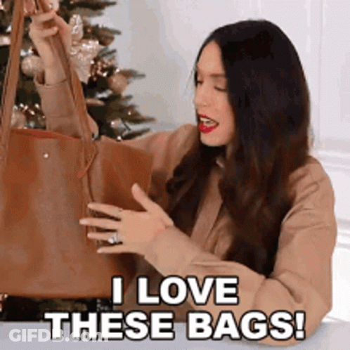 A Woman Is Holding A Brown Tote Bag And Saying I Love These Bags . GIF