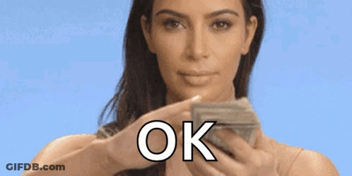 A Woman Is Holding A Bunch Of Money In Her Hands And Saying Ok . GIF