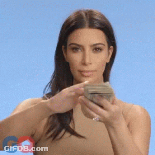 A Woman Is Holding A Bunch Of Money In Her Hands And Throwing It In The Air . GIF