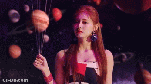 A Woman Is Holding A Bunch Of Planets In Her Hands In Front Of A Planetarium . GIF