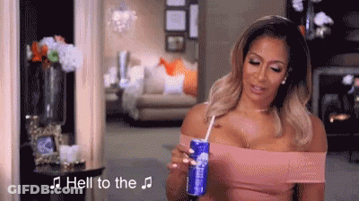 A Woman Is Holding A Can Of Soda Through A Straw In Her Hand . GIF