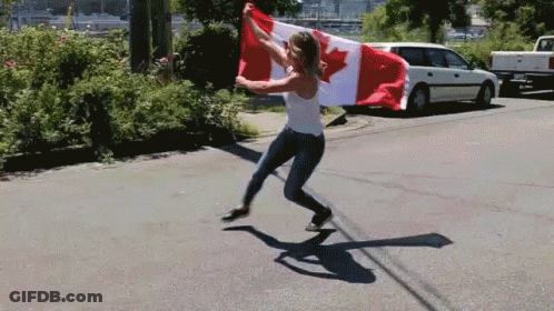 A Woman Is Holding A Canadian Flag In Her Hands GIF