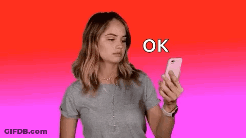 A Woman Is Holding A Cell Phone In Her Hand . GIF