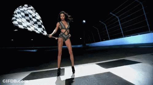 A Woman Is Holding A Checkered Flag On A Race Track GIF
