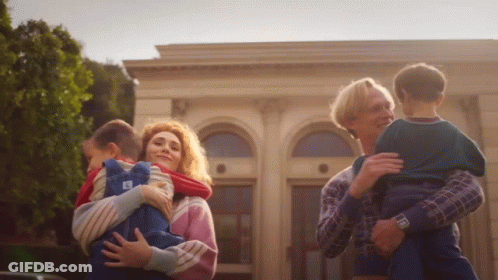 A Woman Is Holding A Child With The Letter E On It GIF