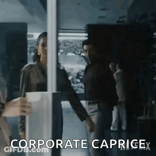 A Woman Is Holding A Cup Of Coffee While Standing Next To A Man In A Dark Room . GIF