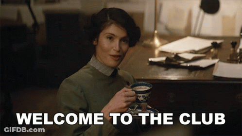 A Woman Is Holding A Cup Of Tea With The Words Welcome To The Club Behind Her GIF