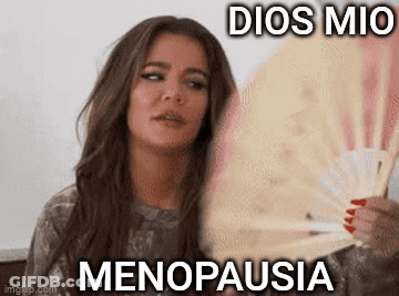 A Woman Is Holding A Fan In Her Hand With The Words `` Dios Mio Menopausia '' Written On It . GIF