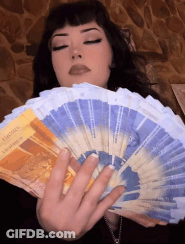 A Woman Is Holding A Fan Of Money That Says ' Switzerland ' On The Front GIF
