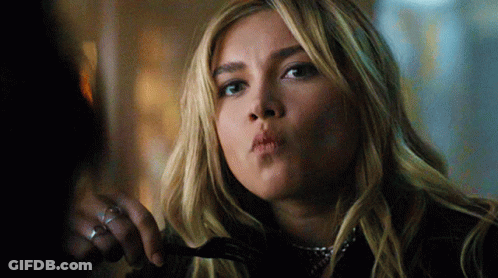 A Woman Is Holding A Fork In Her Hand And Making A Funny Face GIF
