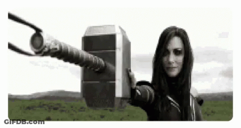 A Woman Is Holding A Giant Hammer In Her Hand . GIF