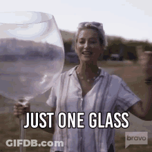 A Woman Is Holding A Giant Wine Glass And Says Just One Glass GIF
