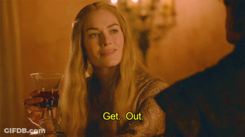 A Woman Is Holding A Glass Of Wine And Saying Get Out GIF