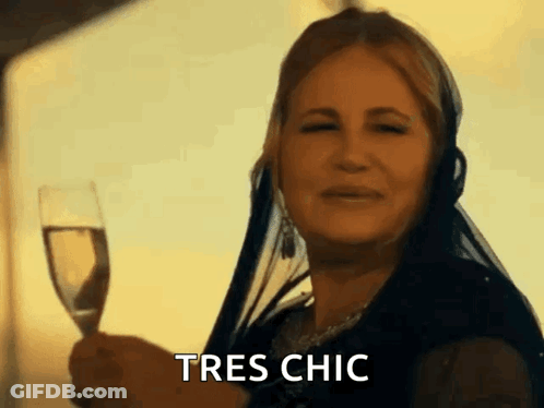 A Woman Is Holding A Glass Of Wine And Says Tres Chic GIF