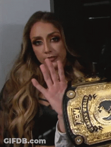 A Woman Is Holding A Gold Aew Women 'S World Championship Belt . GIF