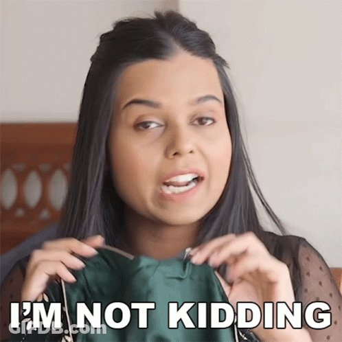 A Woman Is Holding A Green Dress And Says " I 'M Not Kidding " GIF