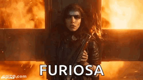 A Woman Is Holding A Gun In Front Of A Fire And The Word Furiosa Is Written On The Screen . GIF