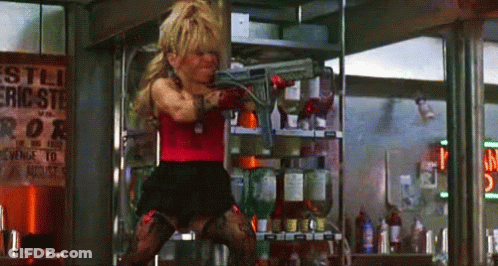 A Woman Is Holding A Gun In Front Of A Sign That Says ' Eric Ste ' On It GIF