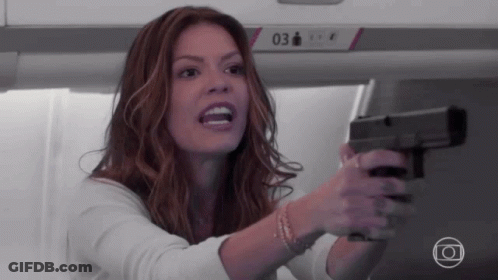 Woman Holding Gun In Front Of Sign 03 GIF