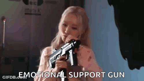 A Woman Is Holding A Gun In Her Hand . GIF