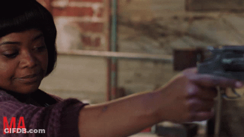 A Woman Is Holding A Gun With The Letter Ma In Red GIF