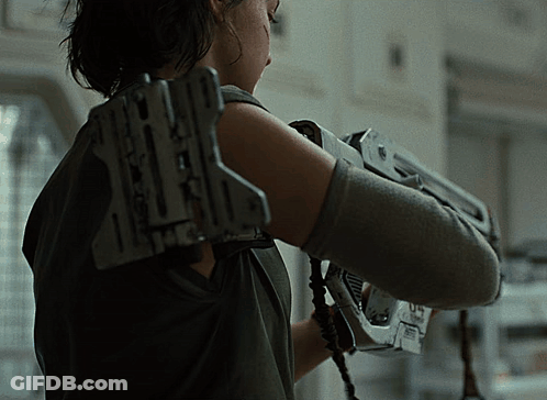 A Woman Is Holding A Gun With The Letter X On The Back GIF