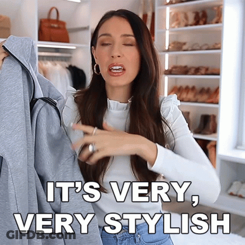 A Woman Is Holding A Jacket And Says It 'S Very Stylish GIF