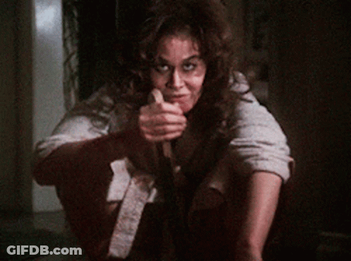 A Woman Is Holding A Knife In Her Hand And Smiling GIF