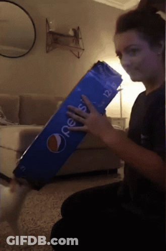 A Woman Is Holding A Large Pepsi Box GIF