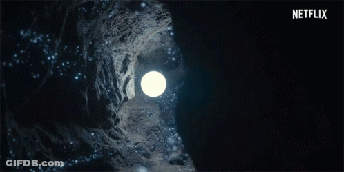 A Woman Is Holding A Light In A Dark Cave With A Netflix Logo In The Background GIF