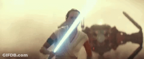A Woman Is Holding A Light Saber In Front Of A Robot In A Star Wars Movie . GIF