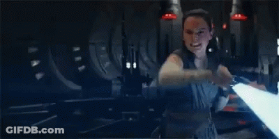 A Woman Is Holding A Light Saber In Her Hand In A Dark Room In A Star Wars Movie . GIF