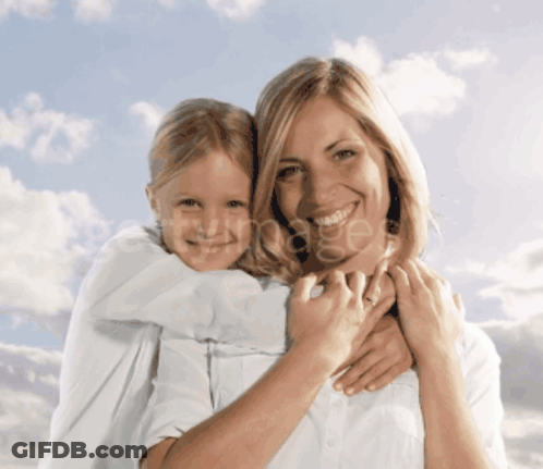 A Woman Is Holding A Little Girl On Her Shoulders And Smiling GIF