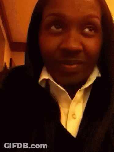 A Woman Is Holding A Lollipop In Her Hand GIF