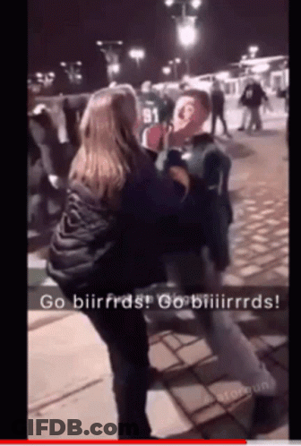 A Woman Is Holding A Man 'S Face In A Video That Says Go Biirfras GIF