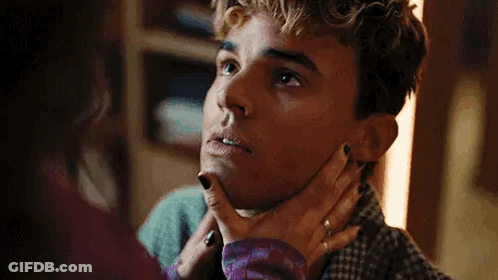 A Woman Is Holding A Man 'S Neck And Looking At Him . GIF