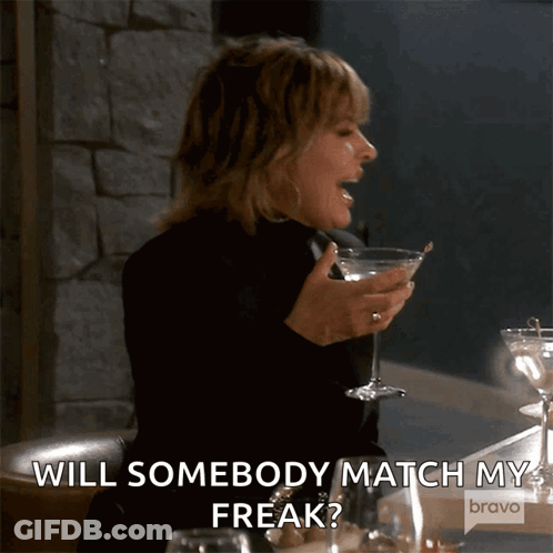 A Woman Is Holding A Martini Glass And Saying " Will Somebody Match My Freak ? " GIF