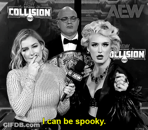 A Woman Is Holding A Microphone In Front Of A Sign That Says I Can Be Spooky GIF