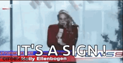 A Woman Is Holding A Microphone In Front Of A Sign That Says `` It 'S A Sign '' . GIF