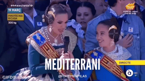 A Woman Is Holding A Microphone With The Word Mediterrane On The Screen GIF