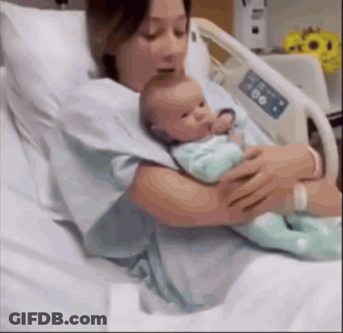 Woman Holding Newborn Baby In Hospital Bed GIF