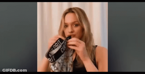 A Woman Is Holding A Pair Of Underwear In Her Hand . GIF